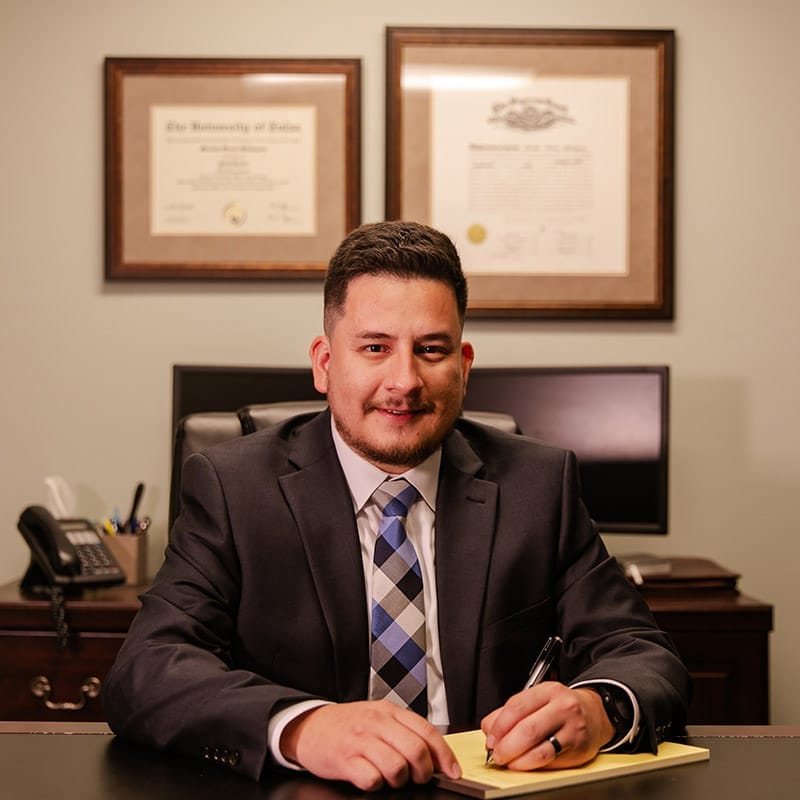 Mosiah Olvera at his desk, beneath his University of Tulsa law degree and Oklahoma bar admission